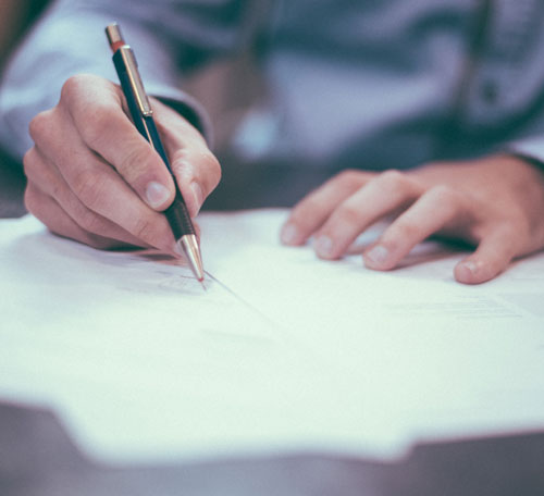 Close-Up Photo of a person writing on a document